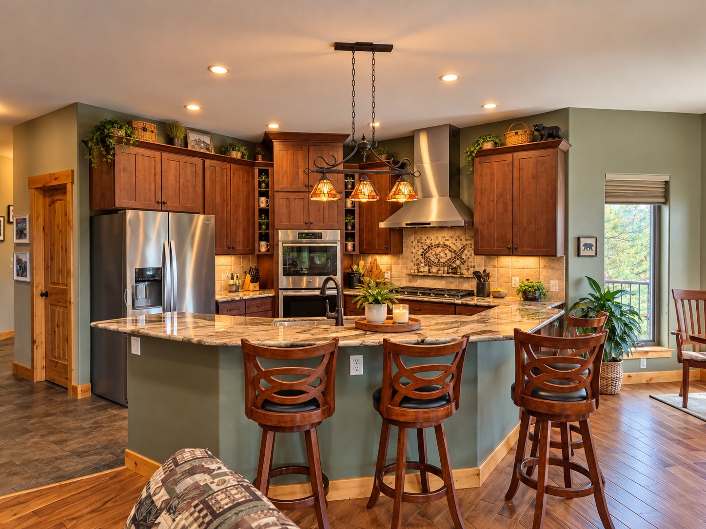 Kitchen with alder cabinets, granite island, mosaic backsplash and pendant lights