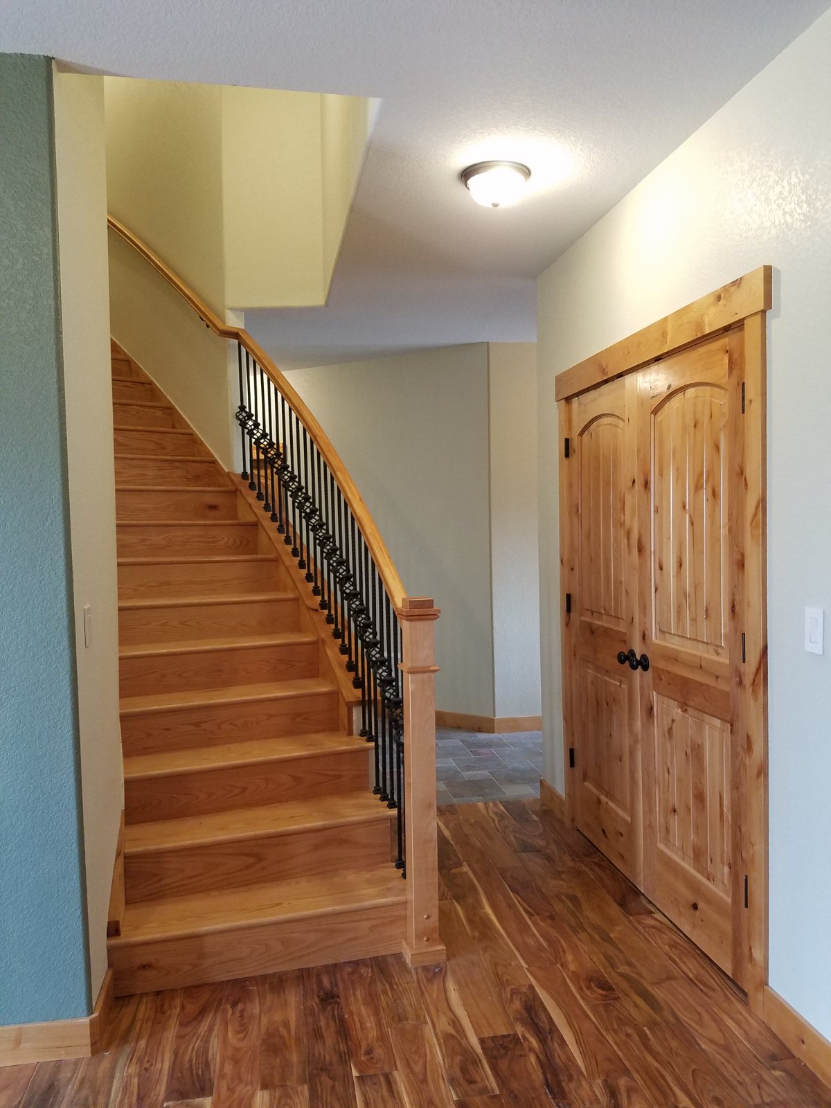 The finished curved staircase in oak with iron balusters
