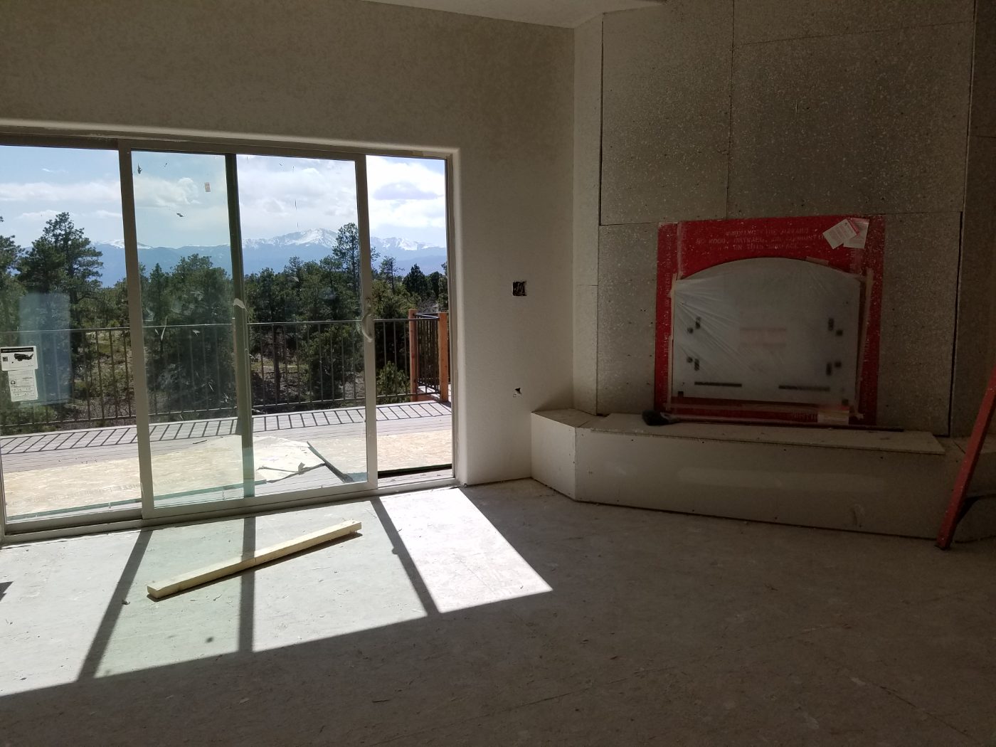 Great room at drywall, sliding door framing a view of Pikes Peak