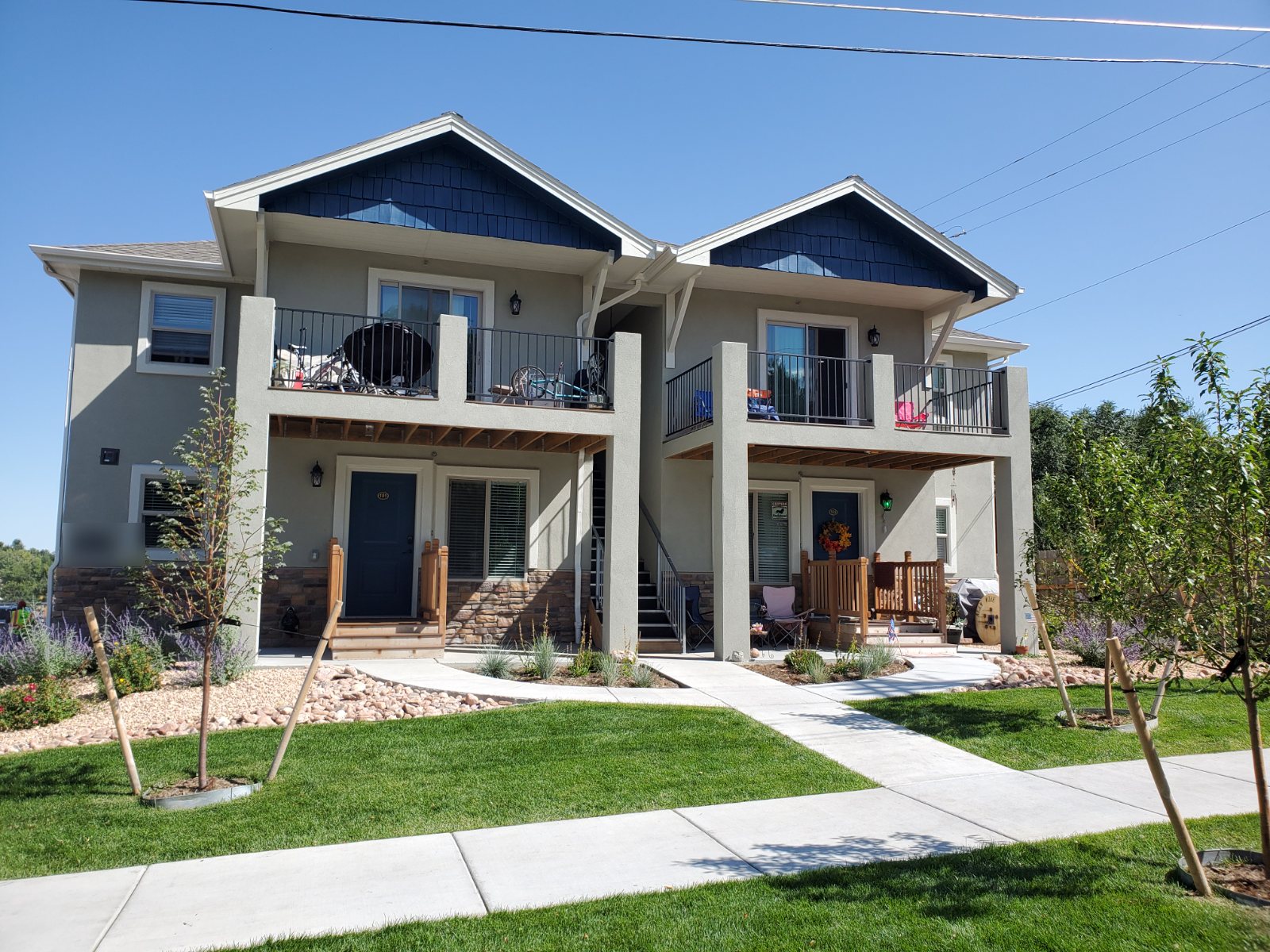 Craftsman-style multi-tenant building with stone base and balconies