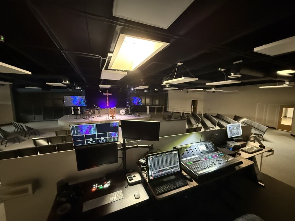 Production booth looking toward the lit stage at Redemption Fellowship