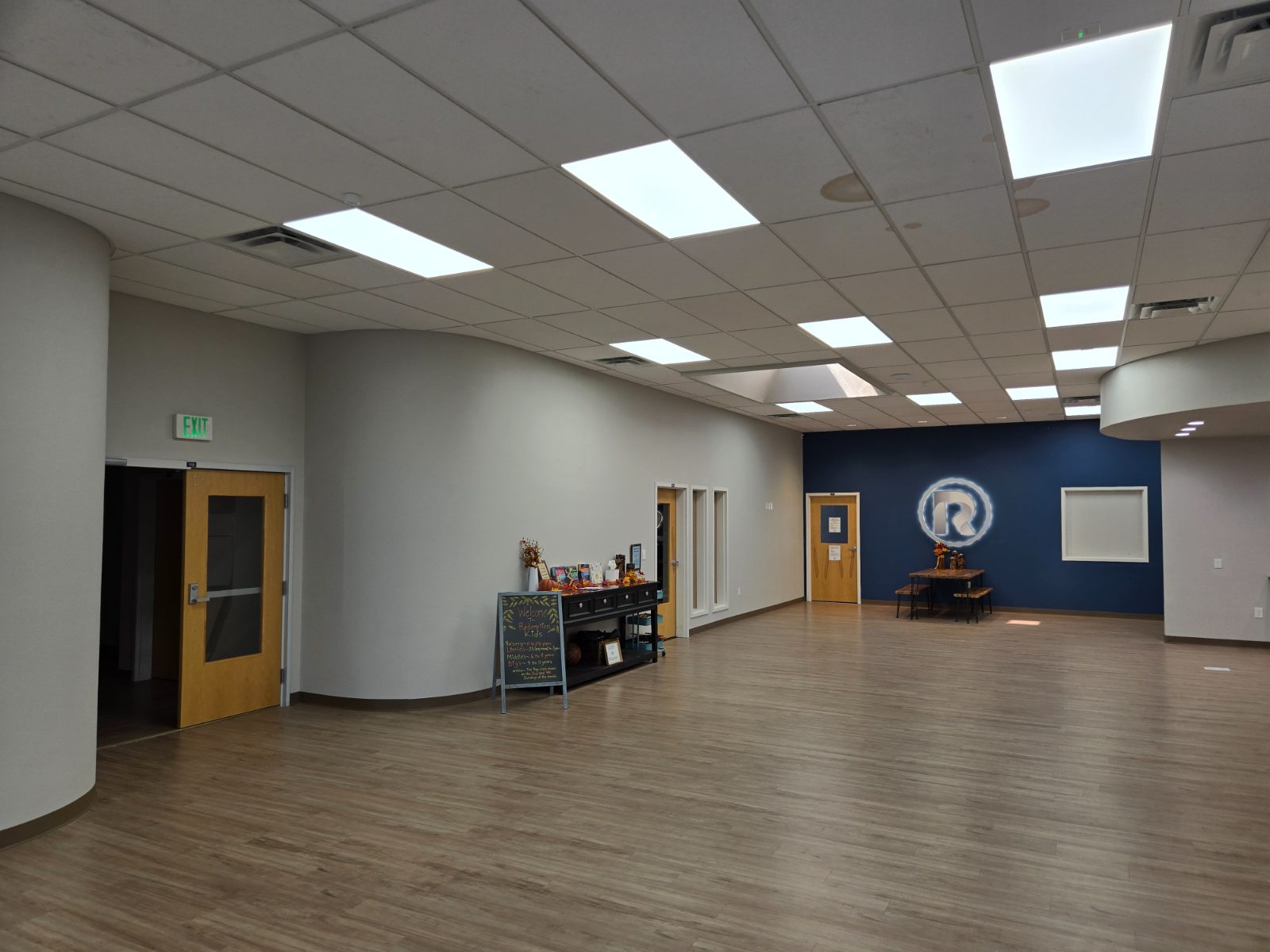 Church lobby with curved walls and a navy feature wall with the illuminated Redemption logo