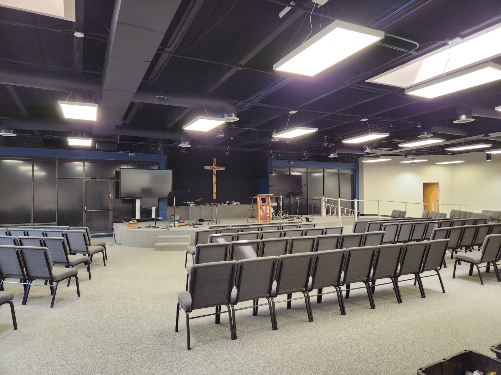 Sanctuary seating facing the stage under suspended light panels