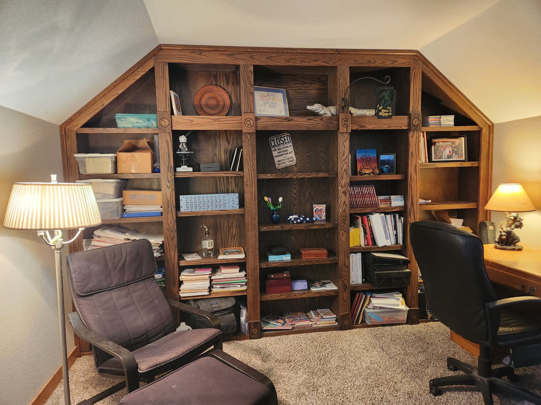 Built-in oak bookcase wall hiding a speakeasy door